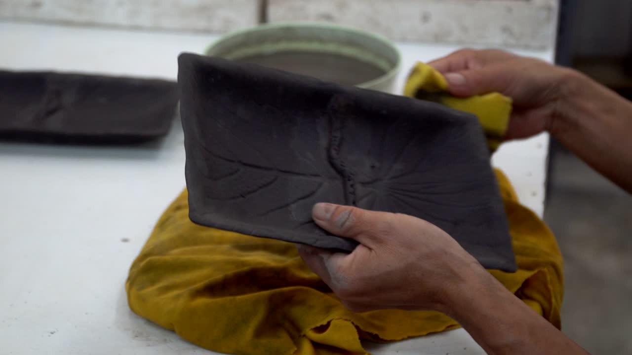 fabricación tradicional de cerámica, primer plano de las manos del alfarero dando forma a un cuenco en el hilado por arcilla