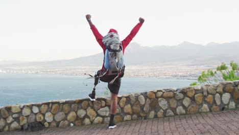 Sporty-mixed-race-man-with-prosthetic-leg-raising-his-arms