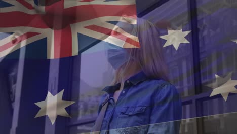 animation of flag of australia waving over caucasian woman wearing face mask in city street