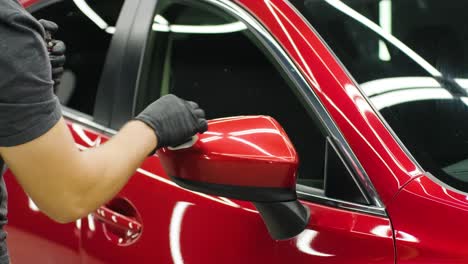 car service worker applying nano coating on a car detail.