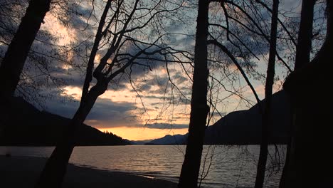 inspiration sunset on lake with mountains in background and tress in foreground