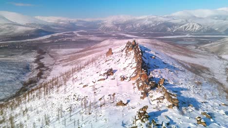 flying nearby over the ridge of a winter mountain at a bird's eye view 4k