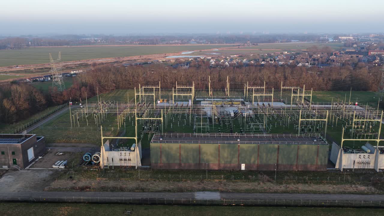 Drohnenvideo aus der Luft von der Hochspannungs-Stromnetzinfrastruktur in den Niederlanden, das Überlandleitungen, Strommasten, Umspannwerke und großflächige Strom- und Energieverteilungsnetze zeigt.
