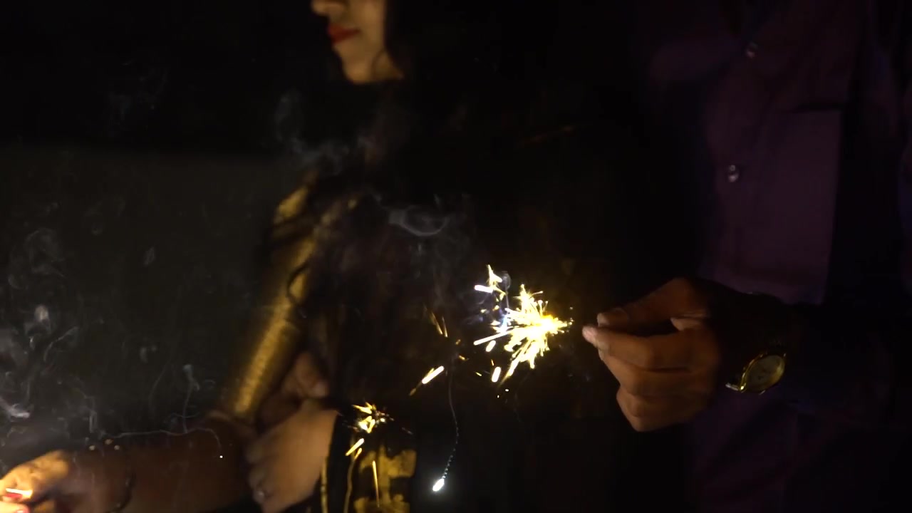 Coppia che tiene in mano una stellina luminosa e festeggia, al rallentatore.