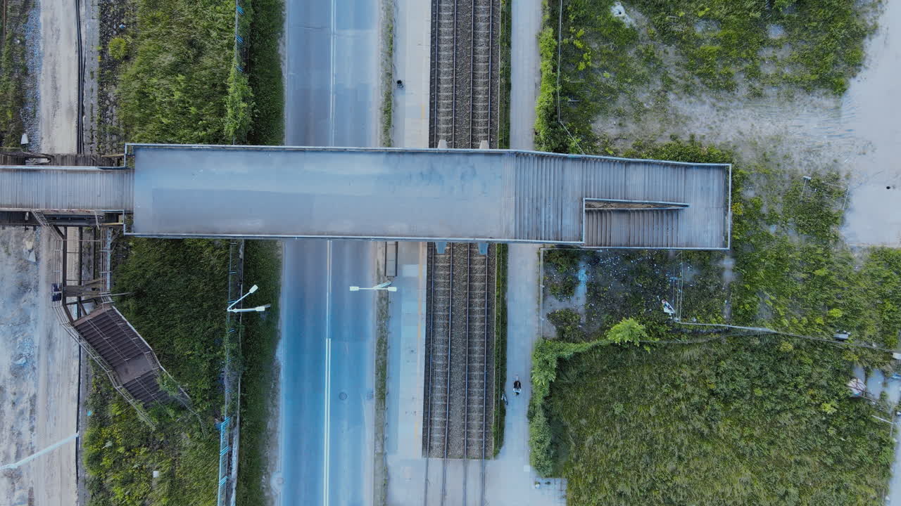 Aerial slow motion shot over no traffic street in the city, railroad tracks near the street