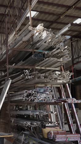 stacked aluminum profiles and metal scraps in a warehouse