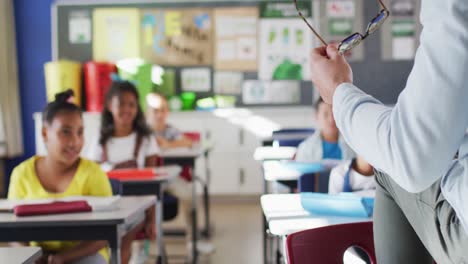 sección media de un maestro masculino diverso que dirige la lección en el aula con niños