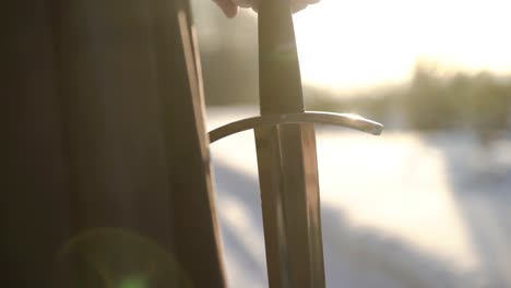 person holding a sword in winter landscape