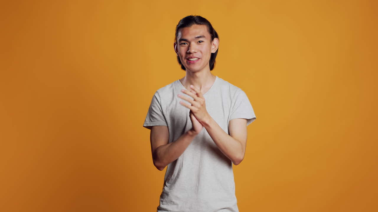 Asian man clapping hands on camera