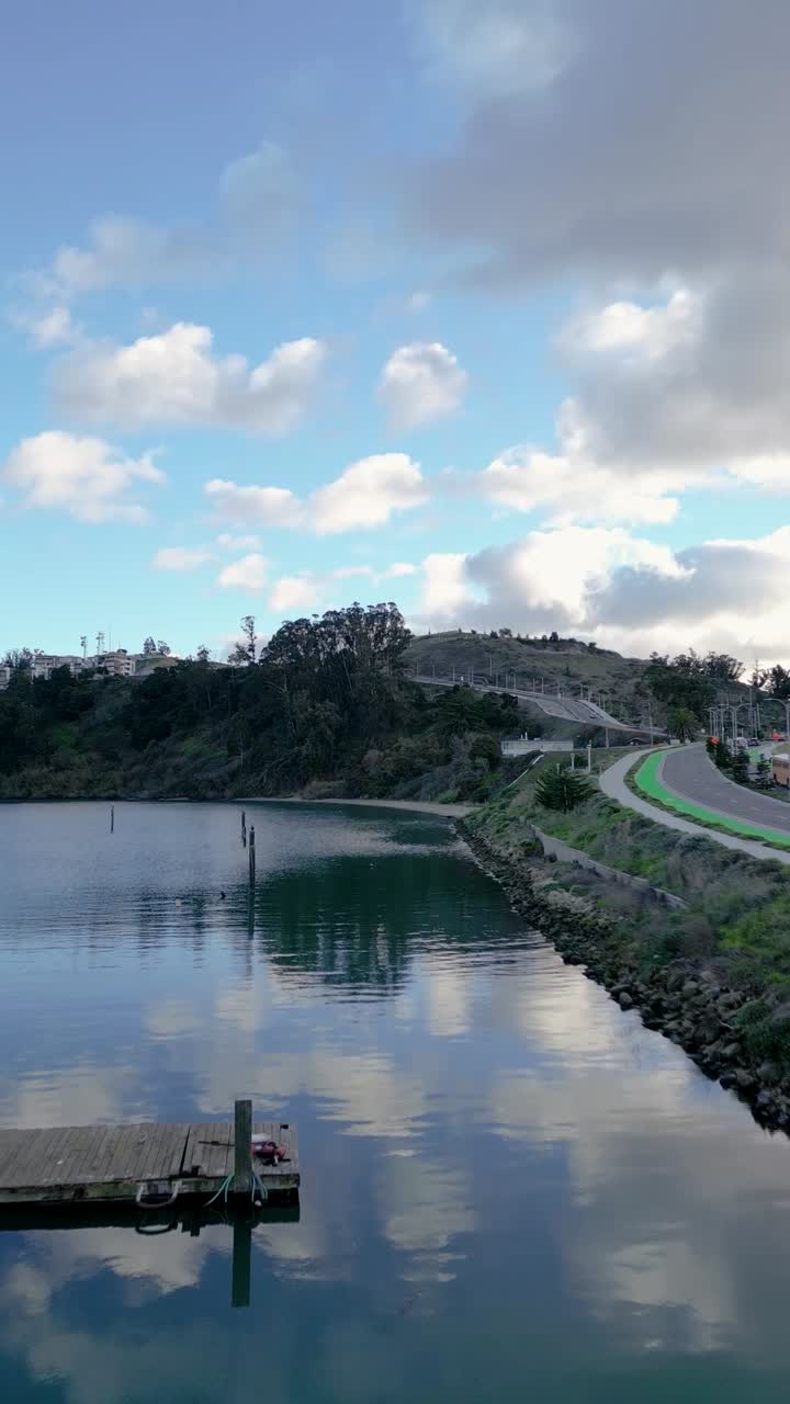 Push-in drone shot of Treasure Isle Marina on Yerba Buena Island, revealing docked boats and the serene waterfront surroundings