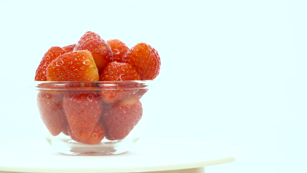 ponga un cuenco de fresas fresas rojas, el cuenco girando