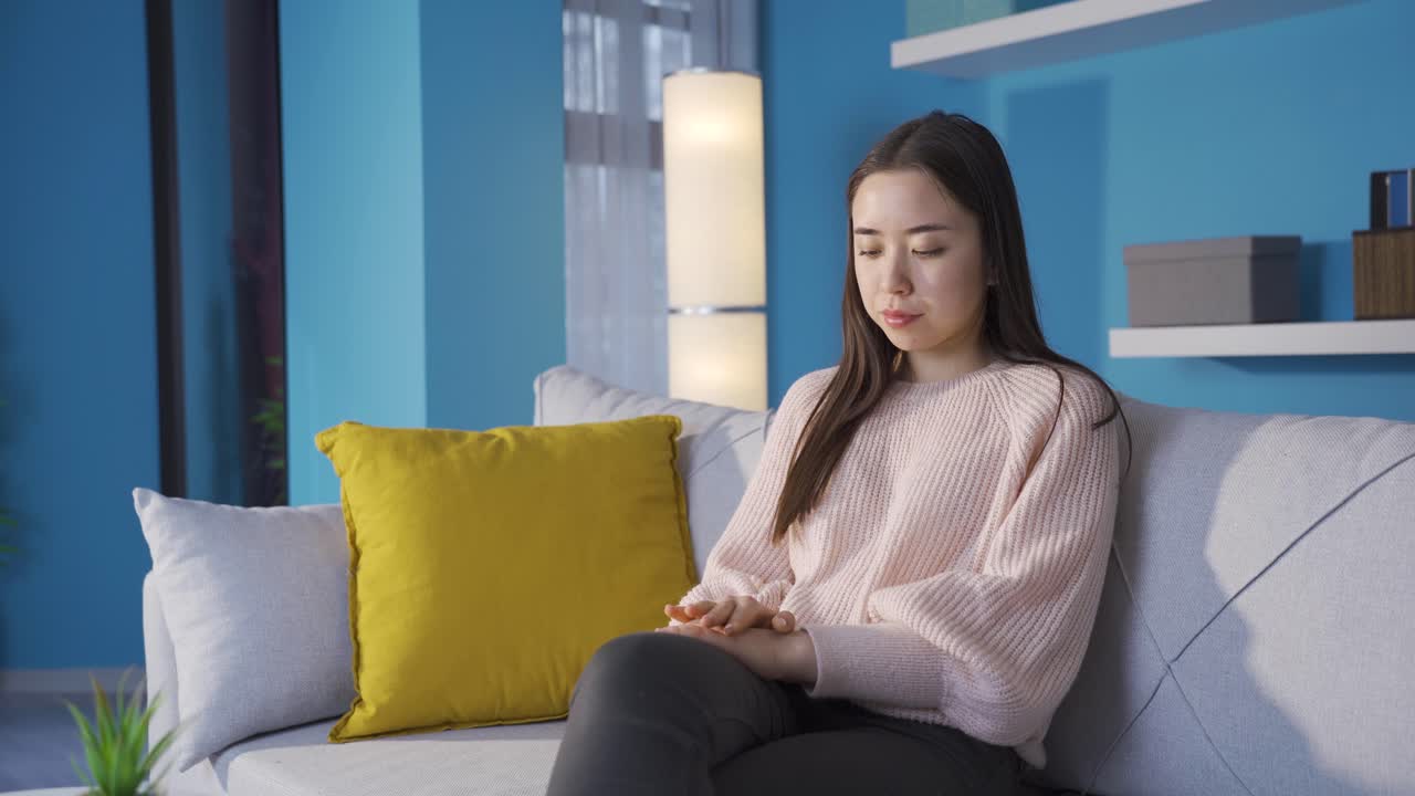 집에서 불행한 사려 깊은 아시아 젊은 여성.