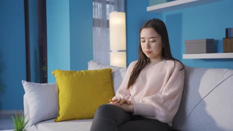 집에서 불행한 사려 깊은 아시아 젊은 여성.