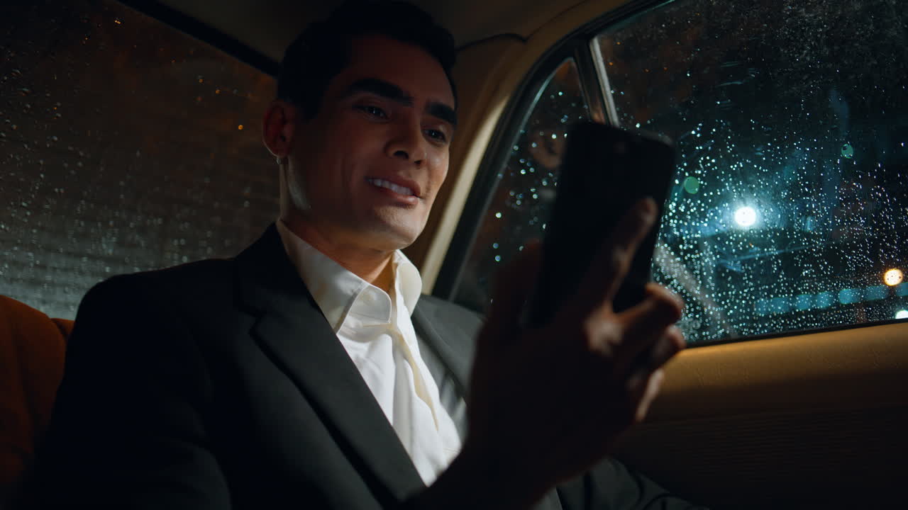 un hombre de negocios alegre con un teléfono móvil de videoconferencia en el coche de cerca.