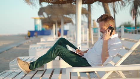 Businessman-making-phone-call-on-beach