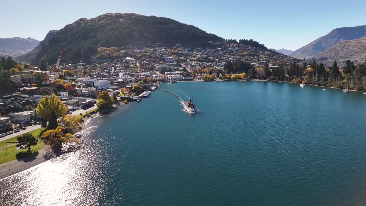 relajante vista de avión no tripulado de un barco de vapor que sale de queenstown, ciudad turística en la orilla del lago