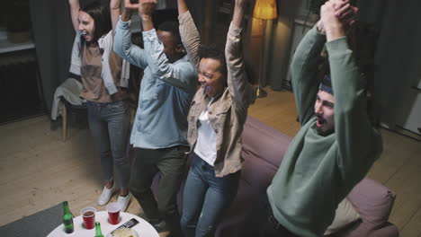 diverse friends cheering while watching sports game