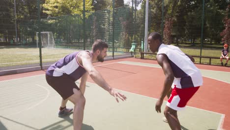 two men playing basketball outdoors