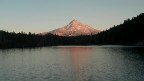 dolly back establishing aerial shot of mount hood from lost lake at sunset