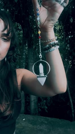 woman holding a crystal pendulum