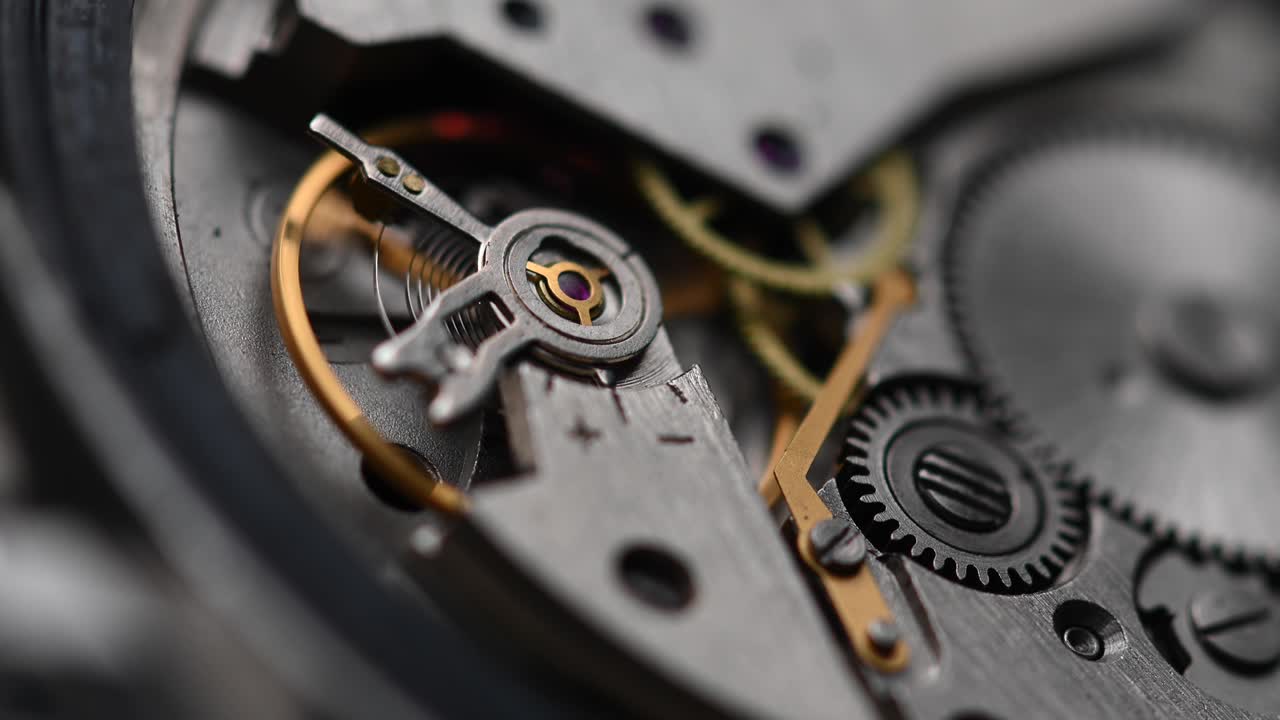 Internal working mechanism of the wristwatch with a rapidly rotating pendulum and gears. 4k clock close up with shallow depth of field