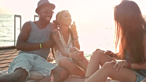 young multi-ethnic hipster friends and couples relaxing on jetty