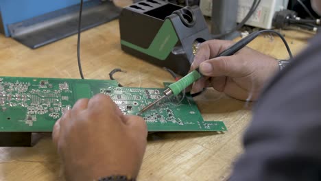 Soldering-circuit-board-for-solar-panel-installation-on-a-workbench,-Orbit-around-close-up-shot