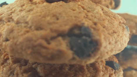 a macro close up shot of a white plate full of well baked chocolate chip cookies, on a 360 rotating stand, studio lighting, slow motion, 4k video