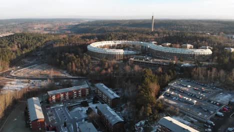 circular apartment building in dense forest, aerial