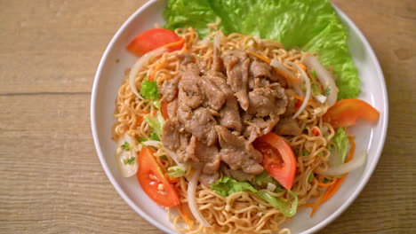 Ensalada-Picante-De-Fideos-Instantáneos-Con-Carne-De-Cerdo-En-Un-Plato-Blanco---Estilo-De-Comida-Asiática