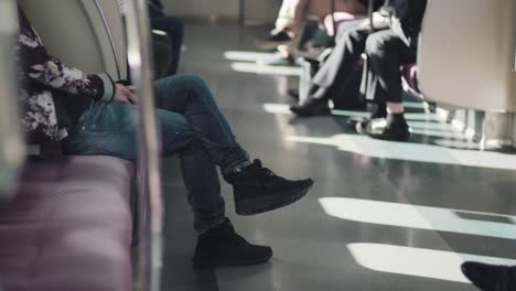 people quietly sitting on a moving train with sunlight coming in from a moving train in tokyo, japan. - wide shot