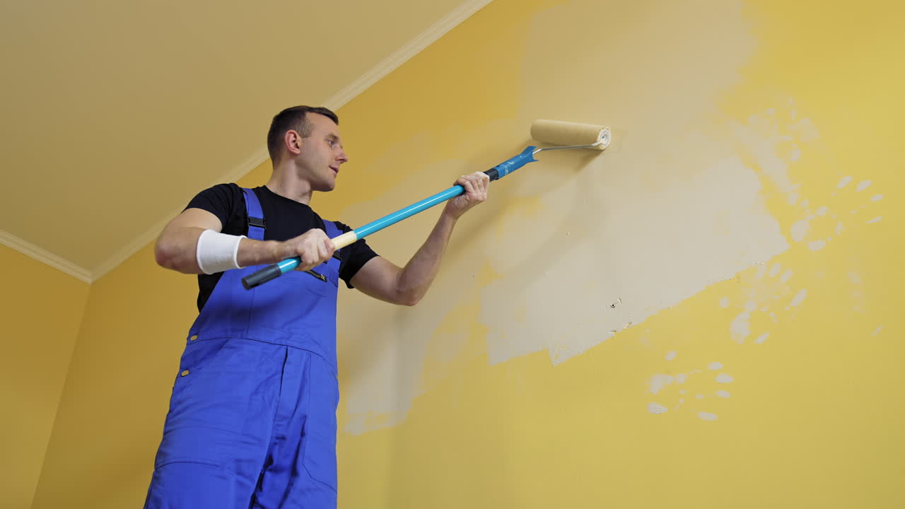 Man doing new room interior with paint. Young handsome male doing renovation.