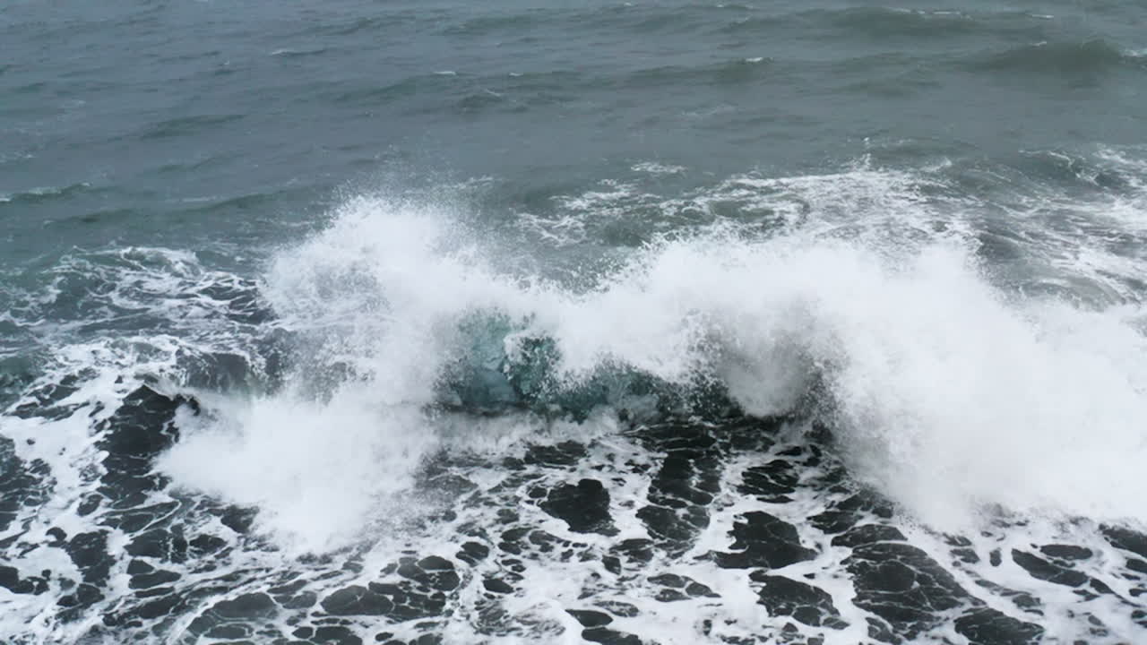 impresionante toma de drones de las olas rompiendo en una hermosa roca de hielo en la playa de diamantes en islandia