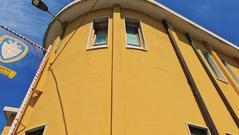 edificio amarillo con letrero y cielo azul