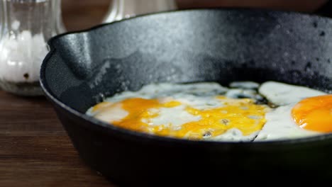 the frying pan with fried eggs slowly rotates on table.