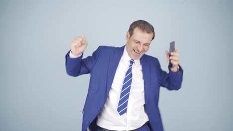 Businessman-dancing-with-phone-in-hand.