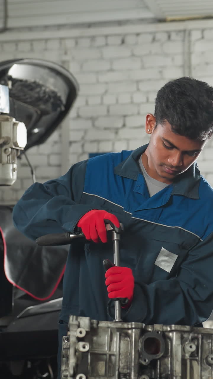 ingenieros automotores en un taller automotriz, uno con guantes rojos trabajando en un motor de coche usando una herramienta mientras un colega observa con la mano en el motor, el fondo presenta vehículos