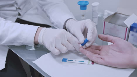 doctor taking blood sample from male hand. man donate blood finger test