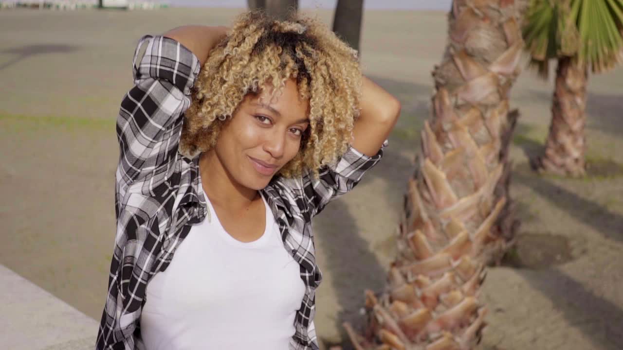 un adolescente lindo sentado en la cornisa con una patineta