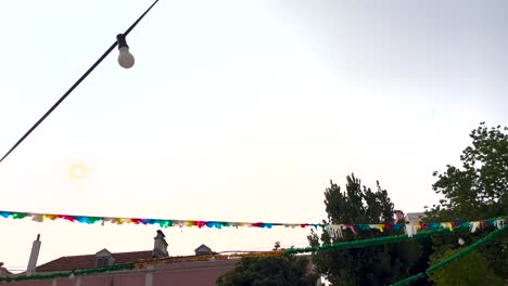 typical saint antonio party in lisbon with a plane passing over the sky with a beautiful sunset