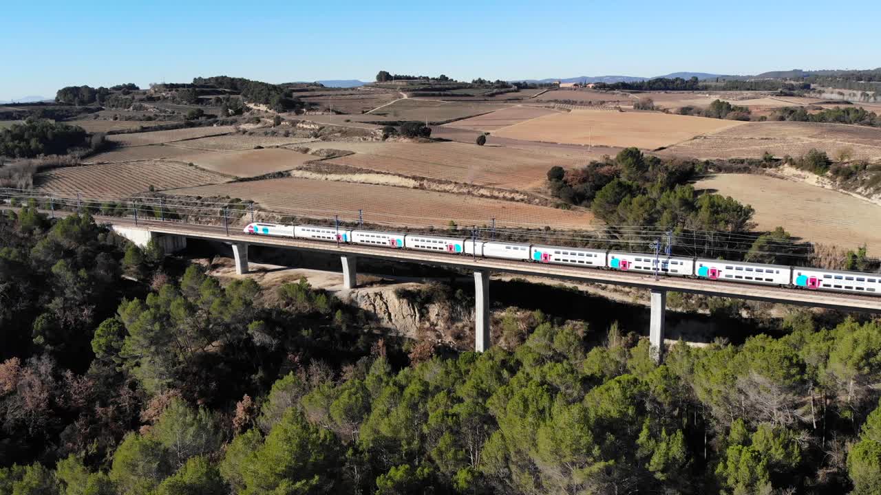 antena: tren de alta velocidad de dos pisos en españa cruzando un viaducto entre barcelona y madrid, en cataluña