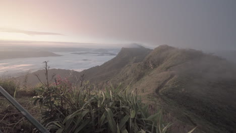 4k-Schwenk-Von-Der-Spitze-Eines-Hügels-In-Thailand-Vor-Sonnenaufgang-Mit-Herrlicher-Aussicht-Auf-Andere-Berge,-Die-Im-Nebel-Liegen,-Und-Mit-Einem-Wolkenmeer-Im-Tal