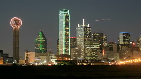 slow pan of city lights illuminating the dallas skyline at night