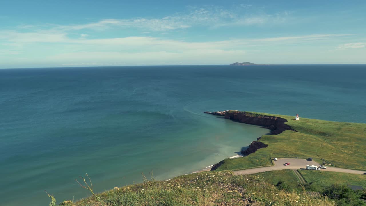 vista del mar desde lo alto de una colina con vistas a una pequeña península que se adentra en el océano