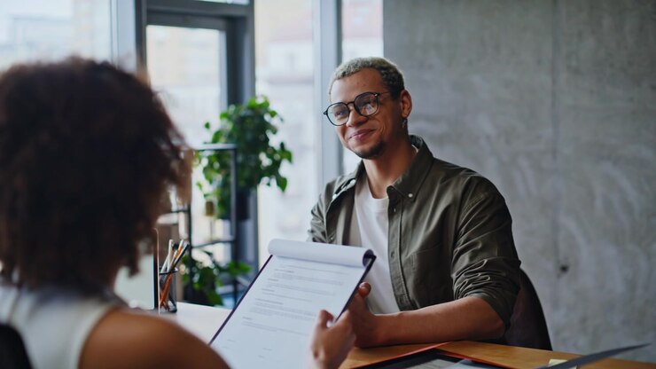 Job interview office meeting, recruiter reviewing resume with male candidate