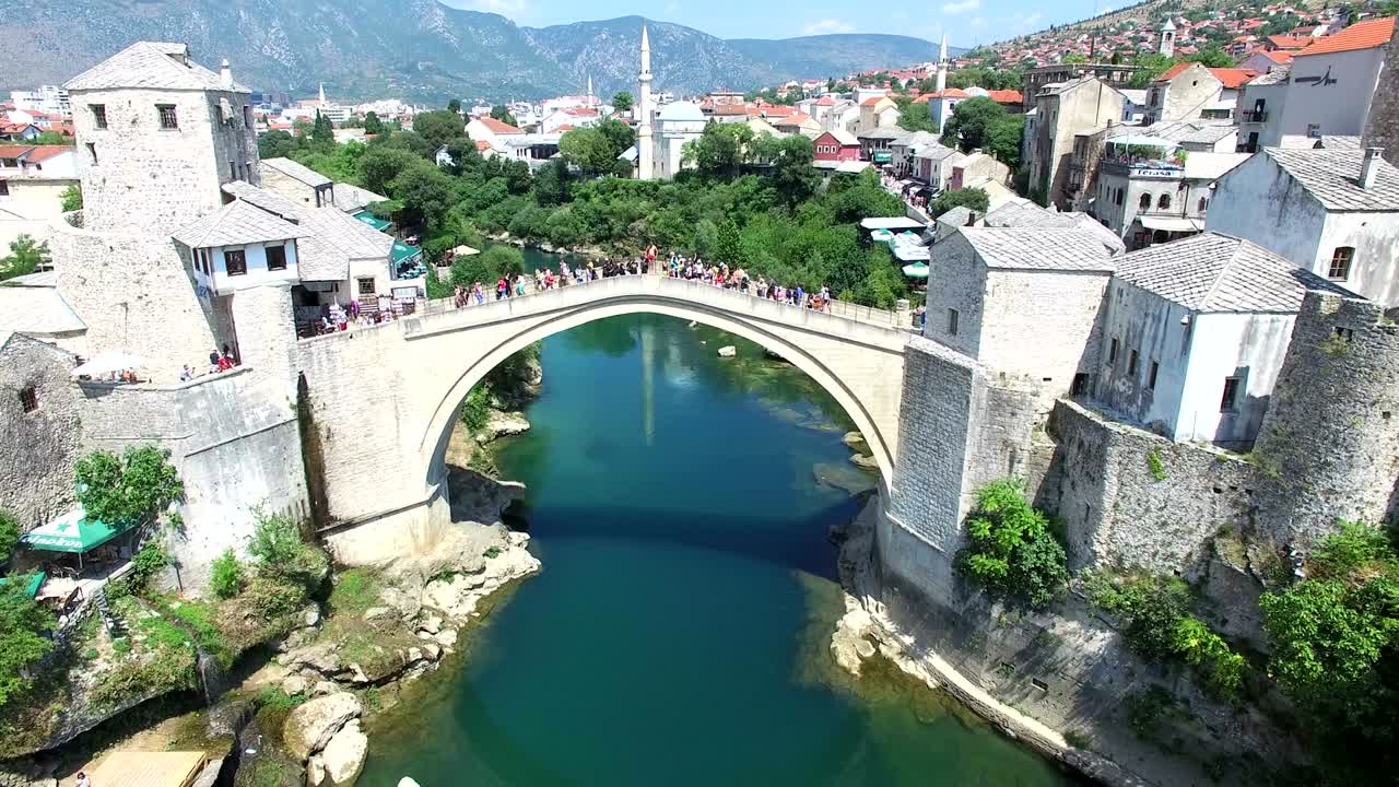 Vista aérea de pessoas a caminhar sobre a ponte em Mostar, Bósnia