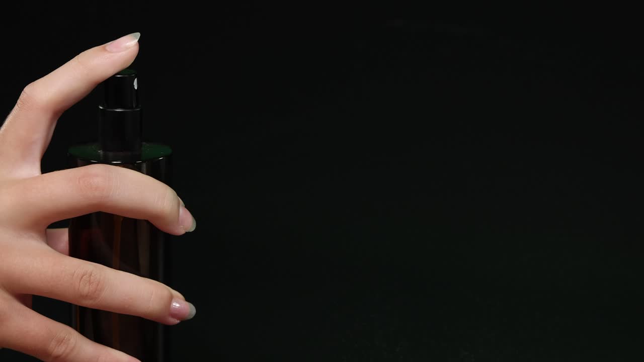 Sequenza di mani che spruzzano profumo nell'oscurità