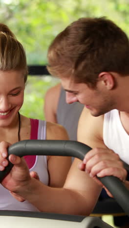 entrenadora hablando con un hombre haciendo ejercicio en bicicleta