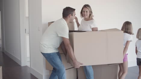 padre y hija felices llevando una caja de dibujos animados