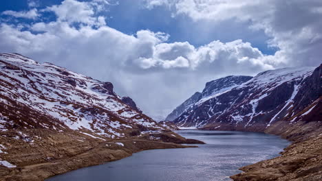 timelapse of a river flowing between mountain hills with snow, norway landscape